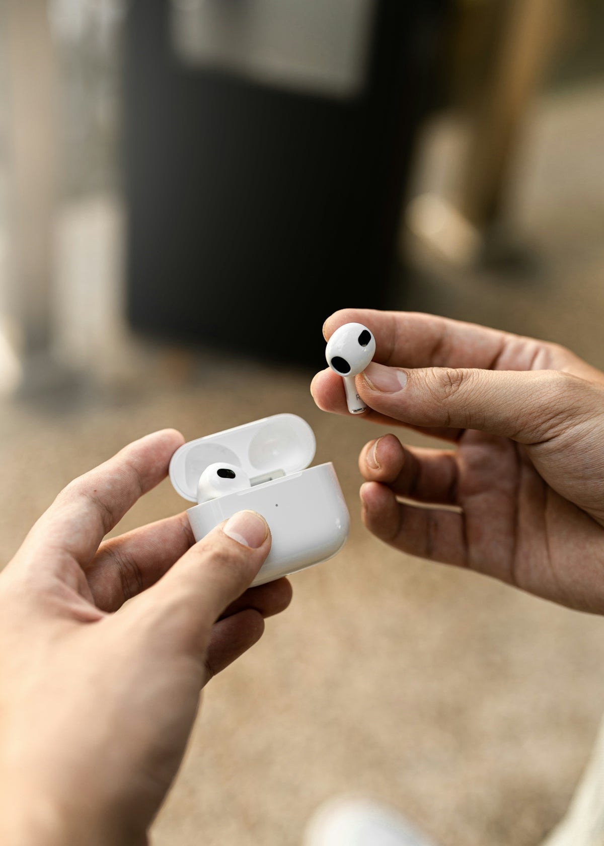 a person holding a pair of airpods in their hands